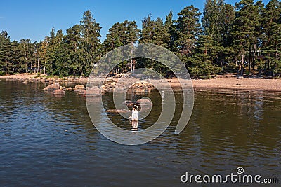 A young woman walks on the water. Lady bathes. Concept of summer vacation, skin and health care, relaxation Stock Photo