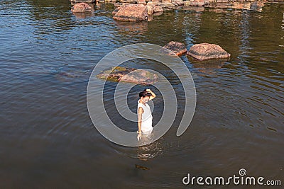 A young woman walks on the water. Lady bathes. Concept of summer vacation, skin and health care, relaxation Stock Photo