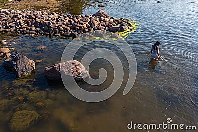 A young woman walks on the water. Lady bathes. Concept of summer vacation, skin and health care, relaxation Stock Photo