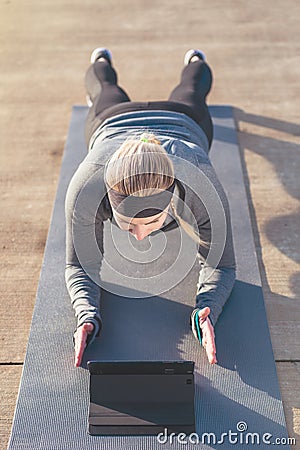 Young woman watching a motivational video while exercising the p Stock Photo