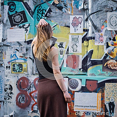Young woman watching street art in Brick Lane, Shoreditch Editorial Stock Photo