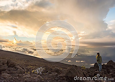 Young woman watching the sun set over Haleakala Crater Stock Photo