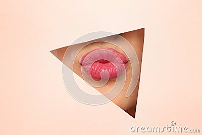 Young woman wearing beautiful lipstick, view through hole Stock Photo