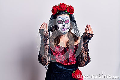 Young woman wearing day of the dead costume over white doing money gesture with hands, asking for salary payment, millionaire Stock Photo