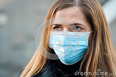 Young woman wearing disposable blue virus face mouth nose mask, closeup portrait. Coronavirus covid-19 outbreak prevention concept Stock Photo