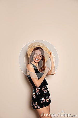 Young woman wearing floral print shorts and straw hat on background Stock Photo