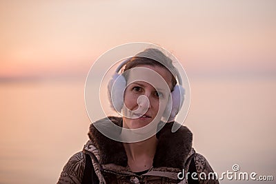 Young woman wearing fluffy ear warmers looking at the camera Stock Photo