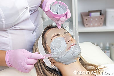 Young woman is wearing a gray alginate mask. Stock Photo