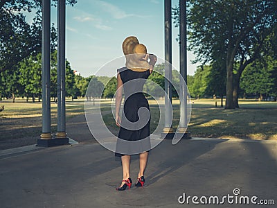 Young woman wearing hat at bandstand in park Stock Photo