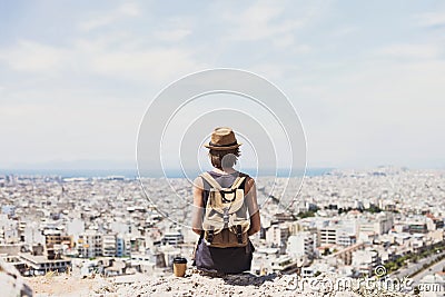 Young woman wearing hat looking at a big city. Traveler girl enjoying vacation. Summer holidays, vacations, travel, concept Stock Photo