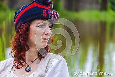 Woman of the napoleonic period sitting on the grass with worried facial expression Editorial Stock Photo