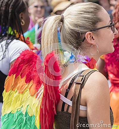 Young woman wearing rainbow angel wings attending the Gay Pride parade also known as Christopher Street Day CSD in Munich Editorial Stock Photo