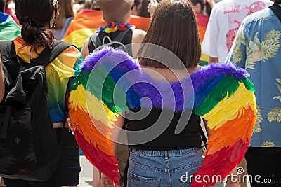 Young woman wearing a rainbow angel wings during the gay pride Editorial Stock Photo