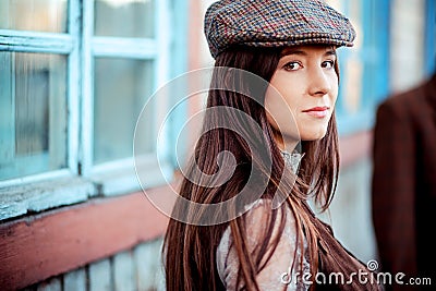 Young woman wearing tweed flat cap old fashioned portrait brown clothes. Stock Photo