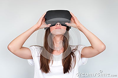 Young woman wearing virtual reality goggles headset, vr box. Connection, technology, new generation, progress concept. Girl trying Stock Photo