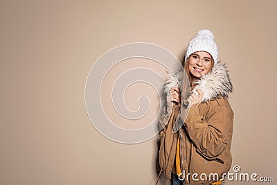 Young woman wearing warm clothes on color background, space for text. Ready for winter Stock Photo