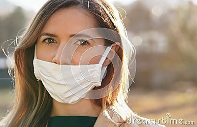 Young woman wears home made white cotton mouth face mask, wrong way, incorrect wearing - masks should cover nose as well Stock Photo