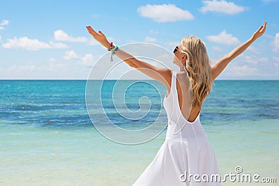 Young woman in white dress enjoying summer day on the beach Stock Photo