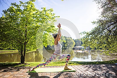 Young woman in white top practicing yoga in beautiful nature. Stock Photo