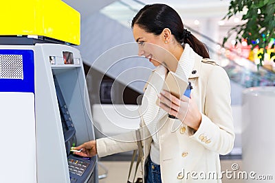 Woman withdrawing cash at an ATM Stock Photo