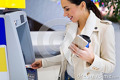 Woman withdrawing cash at an ATM Stock Photo