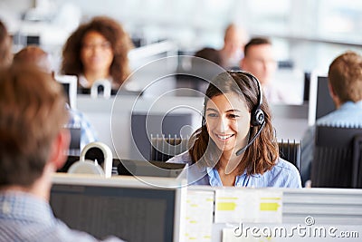 Young woman working in call centre, surrounded by colleagues Stock Photo