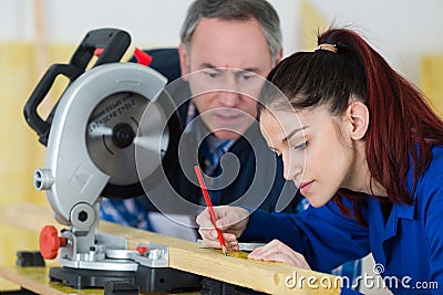 Young woman working at carpenter shop with teacher Stock Photo
