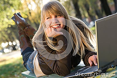 Young woman working with laptop in city park Stock Photo