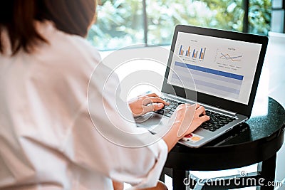 Young woman working on laptop computer while sitting at the living room. Stock Photo