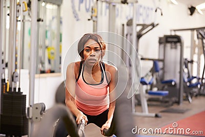 Young woman working out with battle ropes at a gym Stock Photo