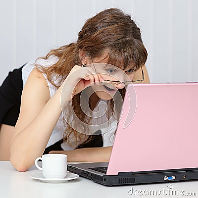 Young woman working with pink laptop Stock Photo