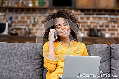 young woman working and talking by phone at home Stock Photo