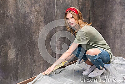 Young woman working with tape and preparing room for renovation home Stock Photo