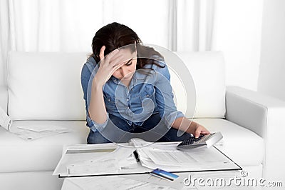 Young woman worried at home in stress accounting bank papers with calculator Stock Photo