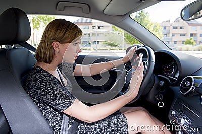 Worried and stressed woman driving car while texting on mobile phone distracted Stock Photo