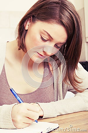 Young woman writes to black diary Stock Photo