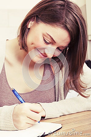 Young woman writes to black diary Stock Photo