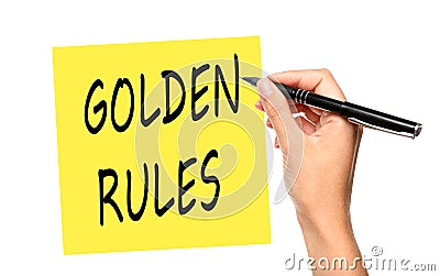 Young woman writing phrase GOLDEN RULES on note against white background, closeup Stock Photo