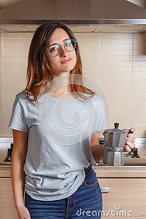 Young women stays in kitchen at home with coffee moka pot Stock Photo