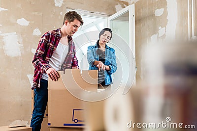 Young woman bringing open box moving in with her boyfriend Stock Photo