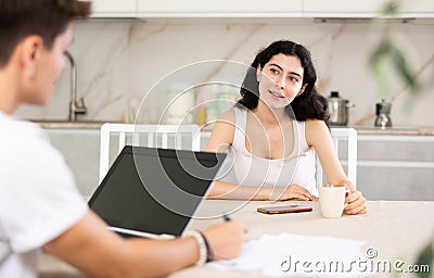 Young woman discussing deal with salesman in kitchen Stock Photo