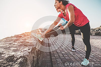 Young woman doing stretching with personal trainer - Fit people training at sunset outdoor - Focus on woman body - Fitness, Stock Photo