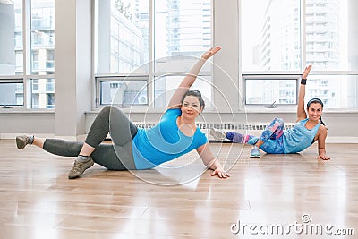 Young women doing workout in gym class indoors to loose weight Stock Photo