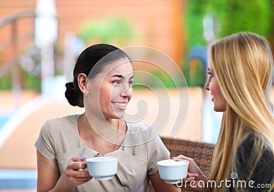 Young women drinking coffee in a cafe outdoors Stock Photo