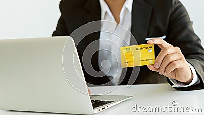 Young women hold credit cards and use laptop computers and mobile telephones to shop online, e-commerce, internet banking, spend m Stock Photo