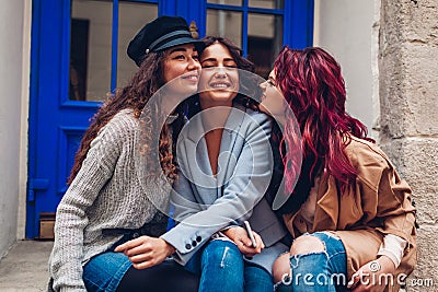 Young women hugging and laughing on city street. Best friends having good time together Stock Photo