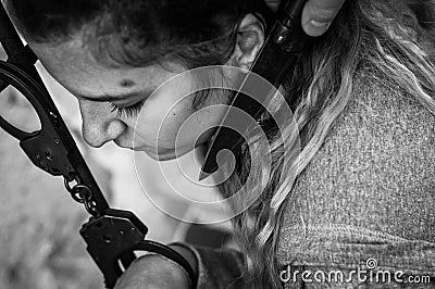 Young women locked with handcuffs to radiator Stock Photo