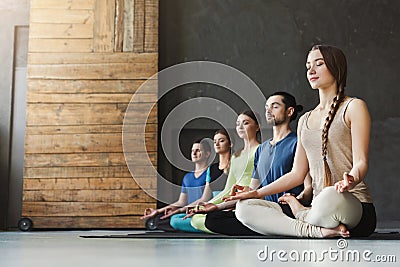 Young women and men in yoga class, relax meditation pose Stock Photo