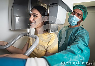 Young woman patient standing in x-ray machine - Dentist doing panoramic dental radiography Stock Photo