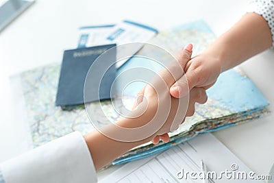 Young female travel agent consultant in tour agency with a customer handshake Stock Photo